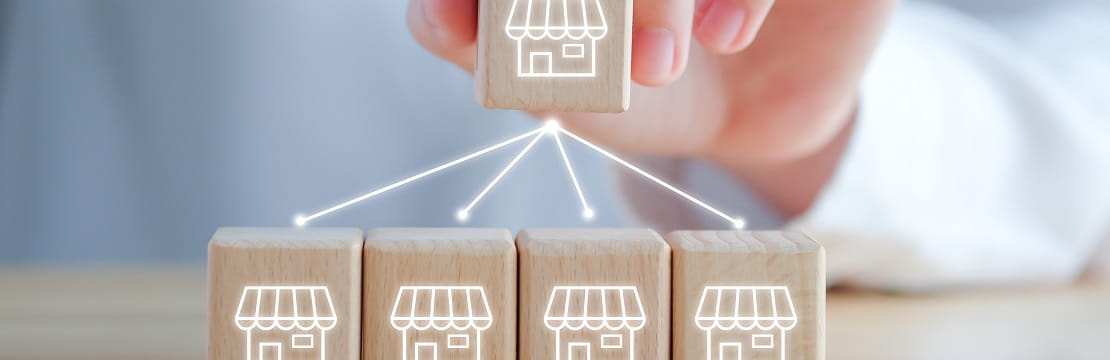 Hand holds a wooden block with arrows pointing downwards towards other blocks.